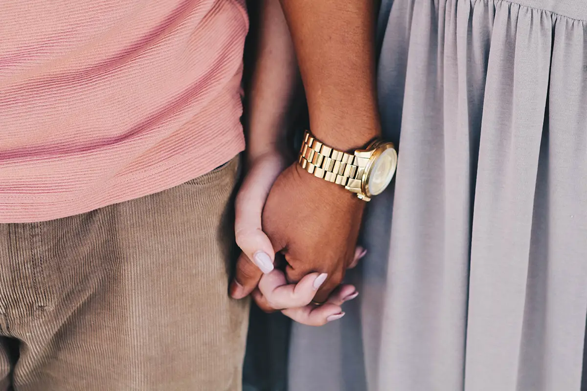 unplash image of couple holding hands for megan thompson's article about cuffing season