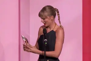 Taylor Swift holding her award for Female Artist of the Decade