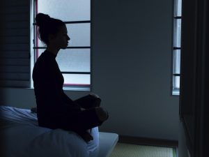 Woman on bed dealing with loneliness