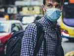 In an article discussing the dangers of stigma and prejudice during a viral pandemic, a man is pictured on the streets with a face mask to prevent a higher chance of catching an illness.