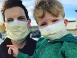 Chris Mann, pictured above with his son, has taken his musical capabilities to create parodies of famous songs to highlight the anxiety and boredom brought on by COVID-19.