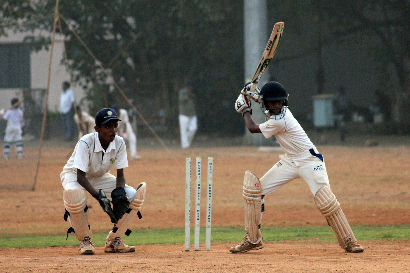 Two people playing cricket, a popular sport in India