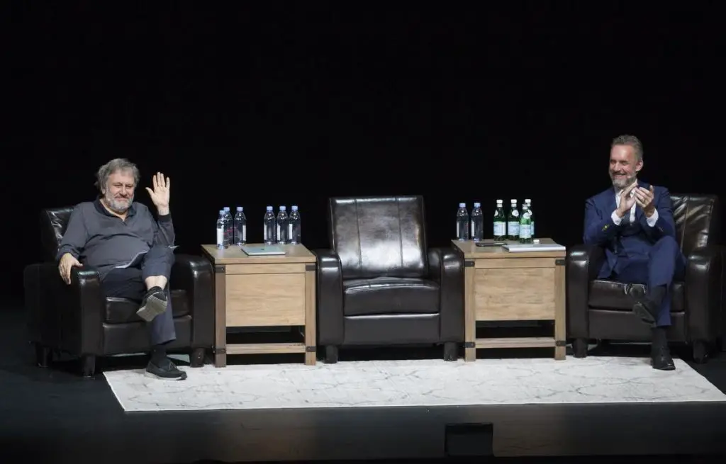 Slavoj Zizek on a debate stage with Jordan Peterson