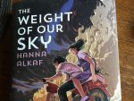 A copy of the YA novel The Weight of Our Sky