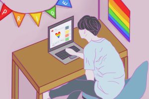 In an article about Pride Month, someone in front of the computer in a room with a rainbow flag