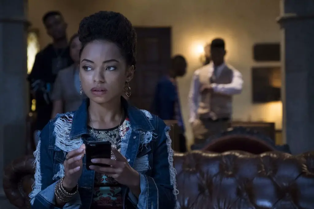 A main character from Dear White People checks her phone