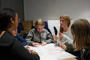 Students discussing plans around a table