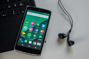 In an article about Instagram accounts, a photo of a phone atop a laptop and next to some earbuds