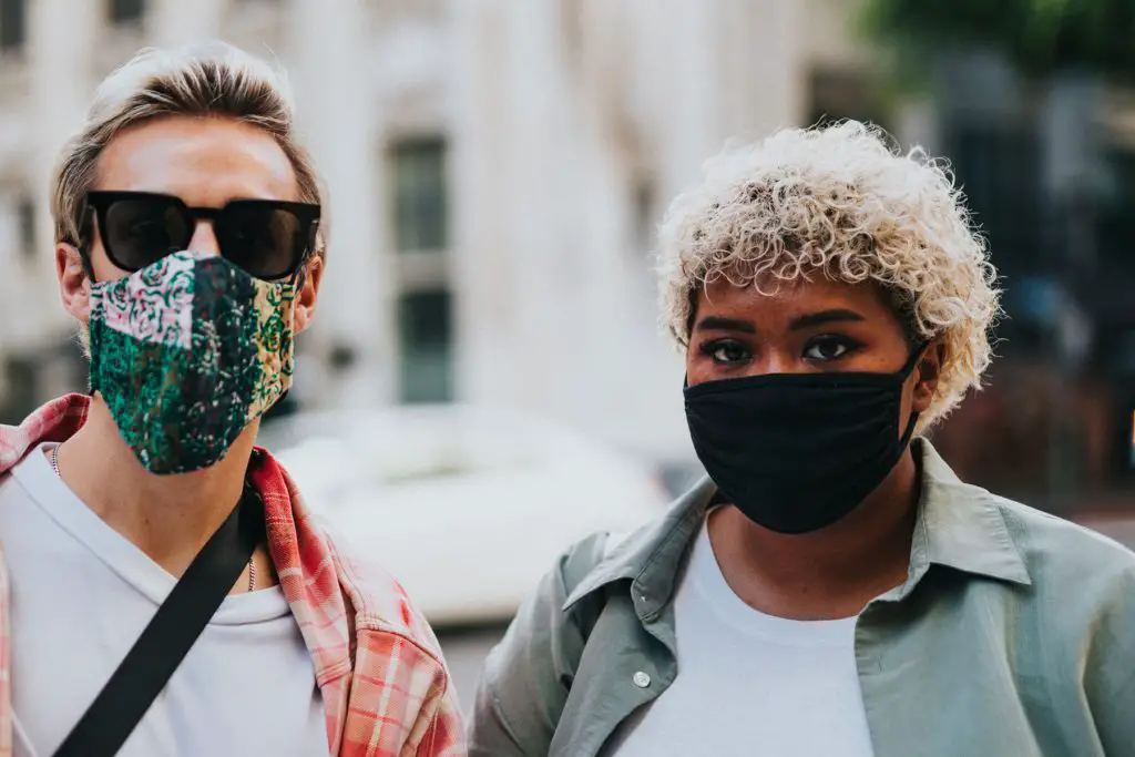 In an article about COVID-19 mourning, two people in face masks