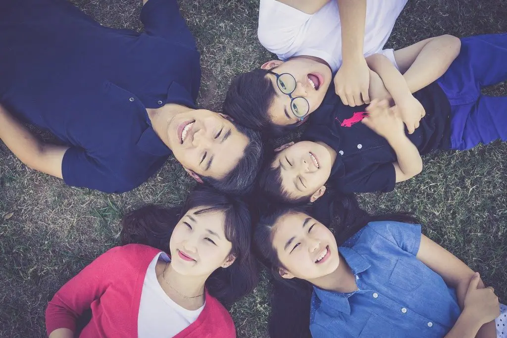 In an article about the 2020 census, a smiling family lies on the grass together