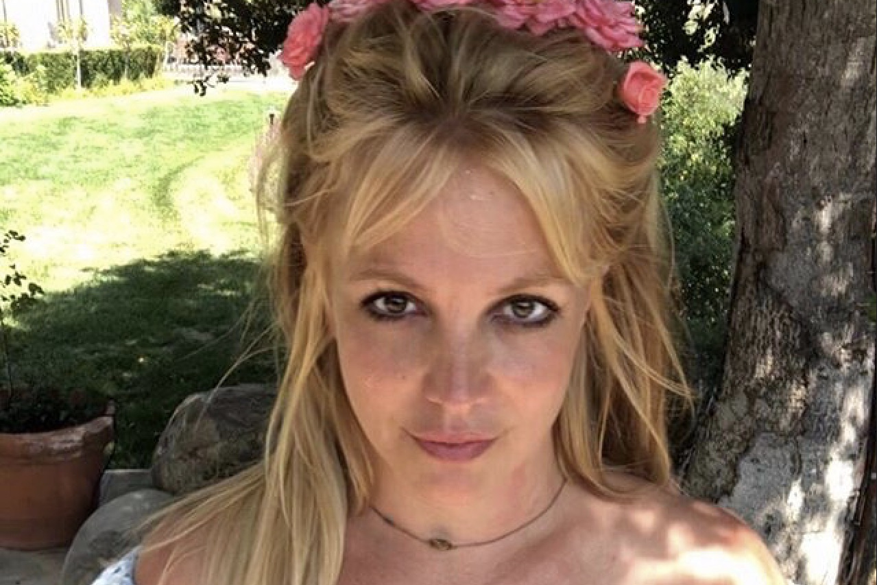 Image of Britney Spears with a pink flower crown staring into the camera on Instagram