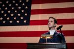 Ben Platt as Payton Hobart gives a political speech in front of the American flag in The Politician.