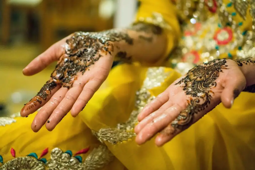 In article about Muslim clothing, woman's hands covered in henna and glitter