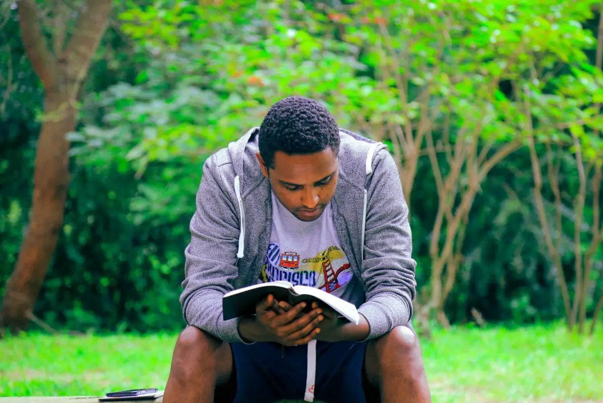 In an article about the OwnVoices Movement, a man outside reading a book