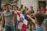 A Latino man and boy hold a flag together in "In the Heights."