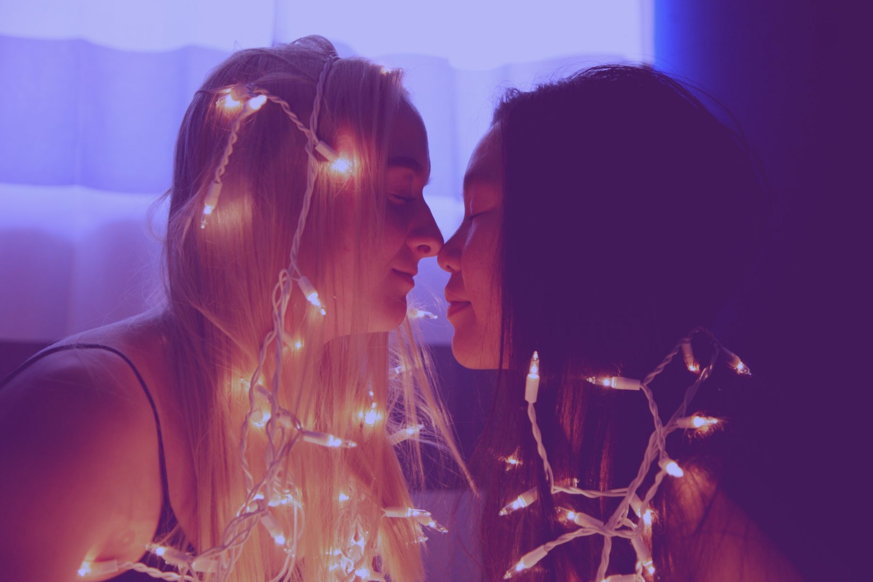In an article about straight women using the phrase "I wish I was gay," a photo of two women in love