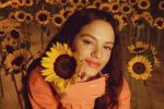 image of artist, Rosalía, among sunflowers