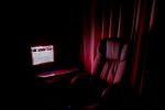 In article about text-based role-playing, a chair and a lit computer screen in a dark room
