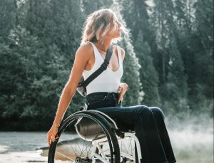 person in a wheelchair in front of a forest