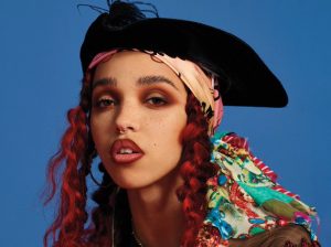 A photo of FKA twigs in front of a blue background
