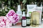 For an article about natural skincare, a photo of peonies next to various bottles of skincare products