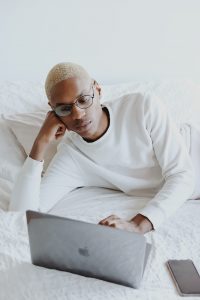 In an article about Calmerry, someone on a bed looking at a laptop