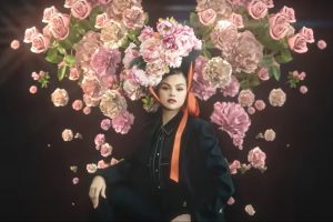 Image of Selena Gomez for her new ep Revelación, wearing a black suit with flowers behind her