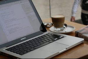 In an article about improving English grades, a computer with a cup of coffee next to it