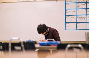 in an article about staying motivated to study, a person doing schoolwork at a desk