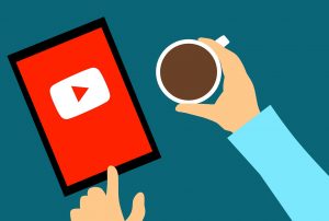 YouTube on a mobile tablet next to a coffee cup