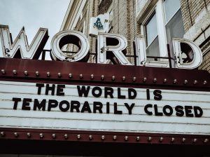 A picture of a movie theatre sign that reads "the World is Temporarily Closed."