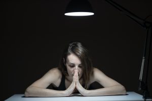 Photo of a woman sitting at a desk looking stressed. (Photo by engin akyurt from Unsplash)