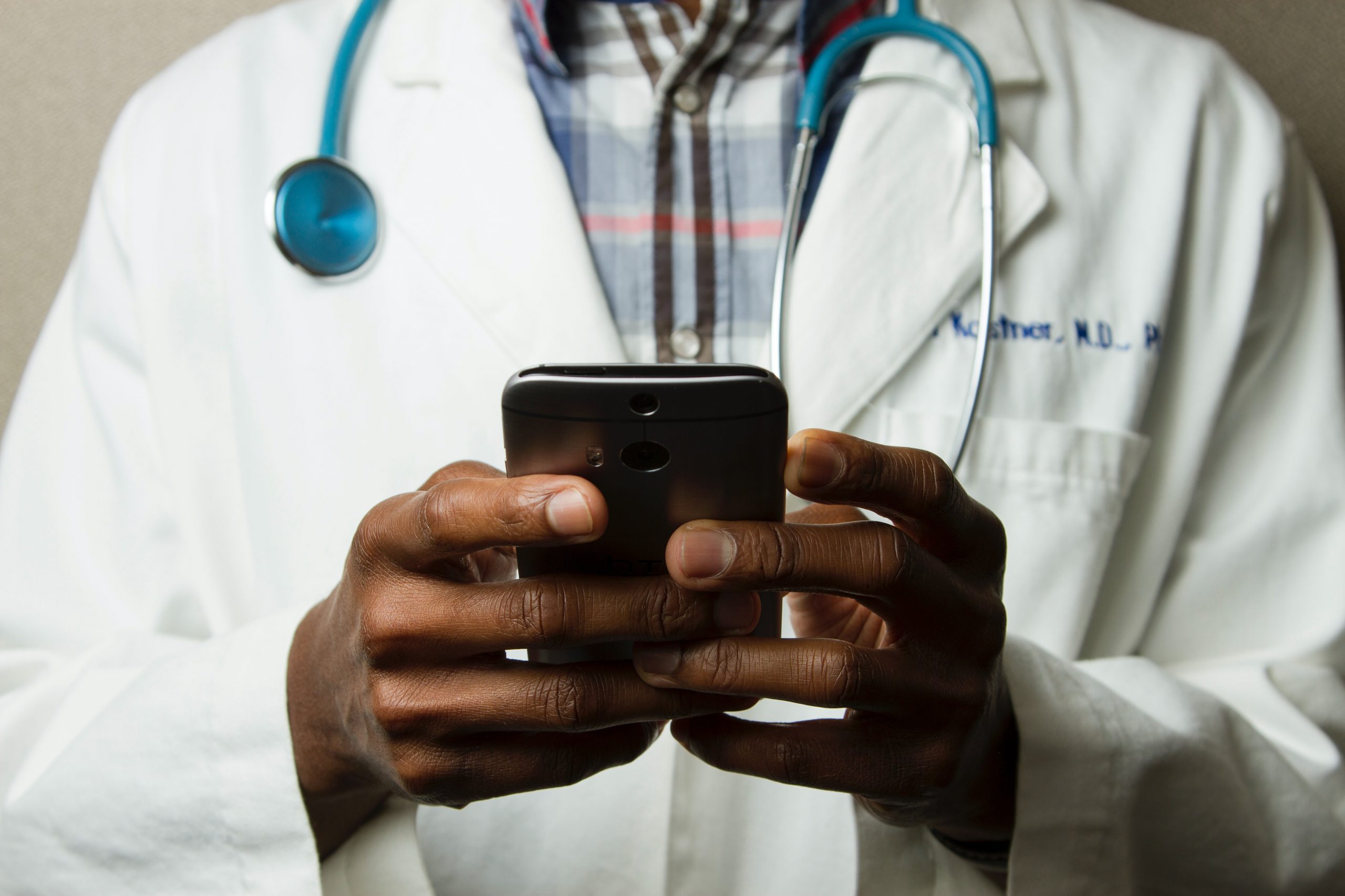 in article about careers, a doctor holding a smartphone