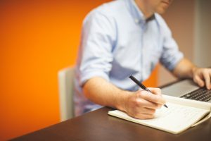 in an article about taking a break at work, a person at a laptop taking notes