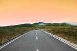in an article about taking a road trip, a sunset on a road
