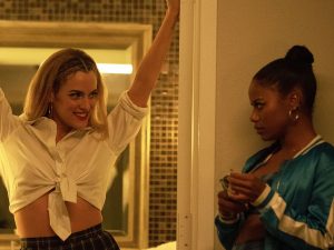 In an article about "Zola," actress Riley Keough stands in a bathroom doorway while Taylour Paige looks at her from the side.