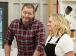 In a show about "Making It," actors Nick Offerman and Amy Poehler stand beside each other in a warehouse.
