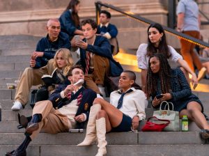 In an article about Gossip Girl, the cast of the reboot sits on a stairwell together.