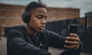 To represent an earworm, a man is pictured listening to music through headphones.