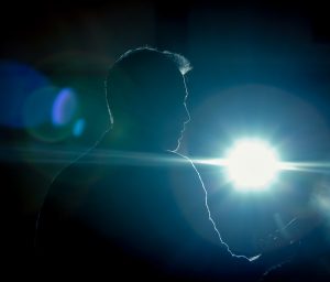 An image of an actor in front of a spotlight