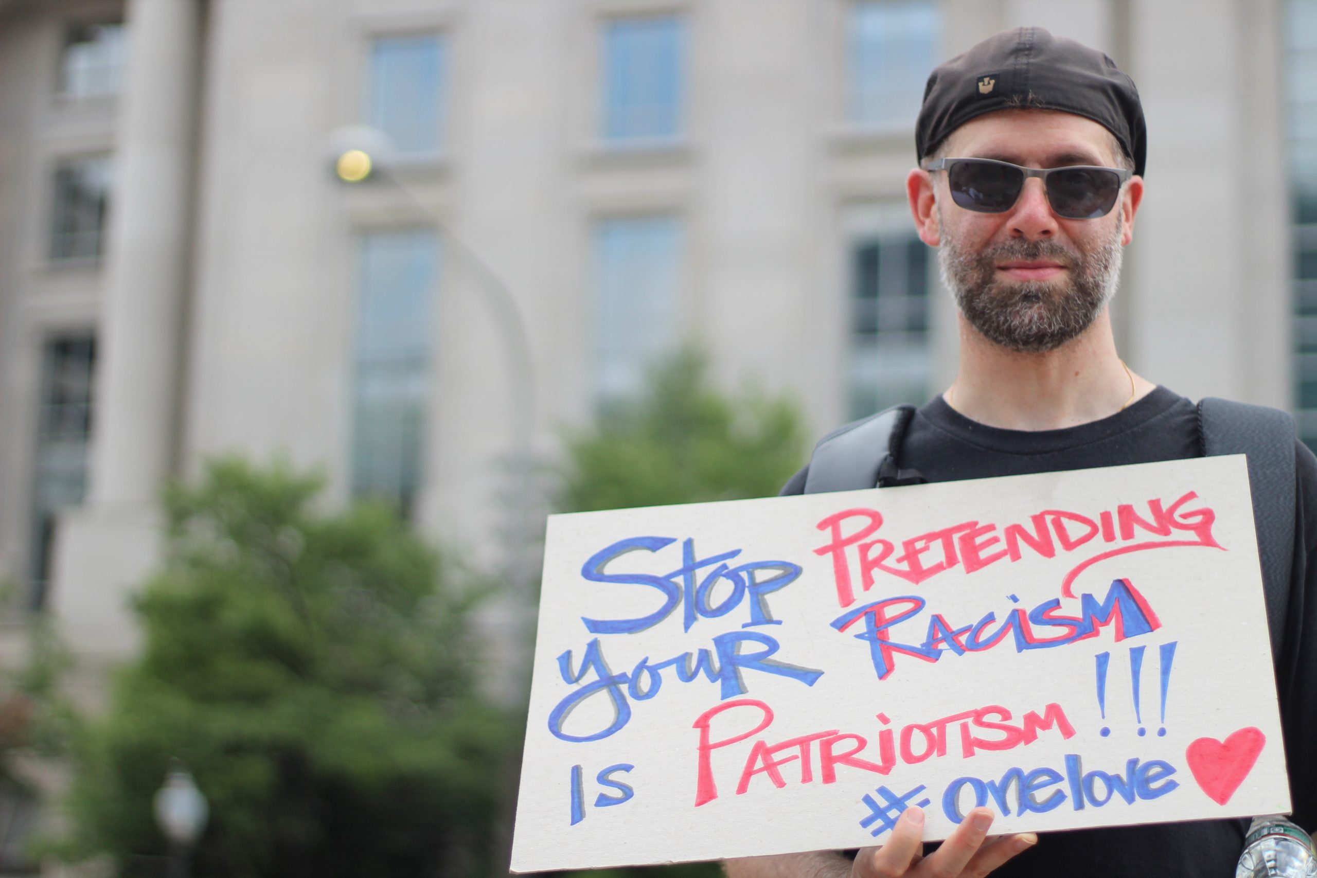 In an article about the Alt-Right Pipeline, an image of a man holding a sign protesting racism.