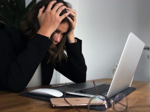 In an article about artist's block, a frustrated woman sitting in front of a laptop