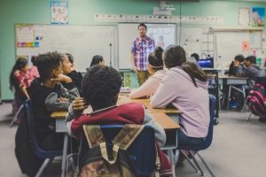 Photo of teachers teaching in room of young student