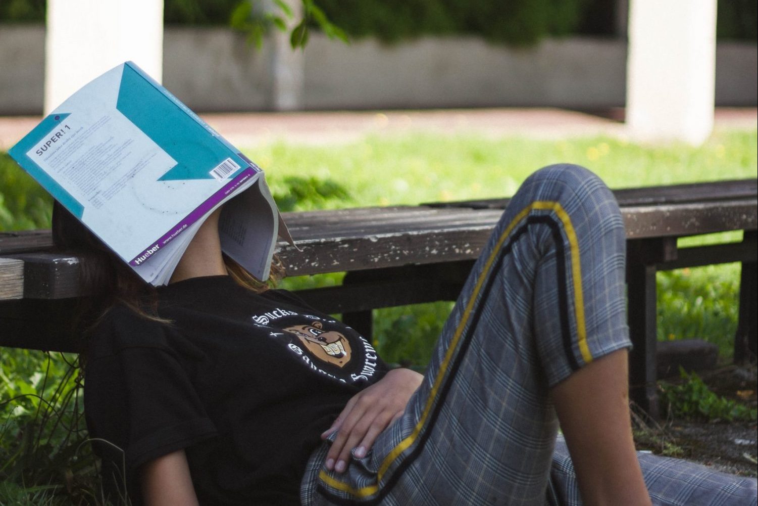 student taking a study break by sleeping with an open book on their face