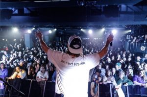 A photo of singer songwriter Cooper Alan in front of a crowd at a concert.