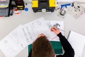 in an article about becoming an engineering project manager, a person working on blueprints