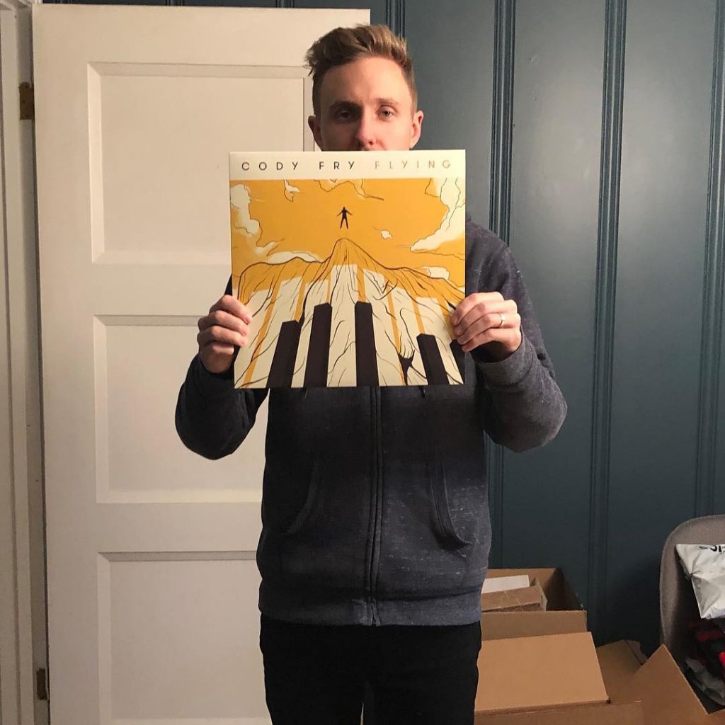 Photo of Cody Fry holding up one of his records