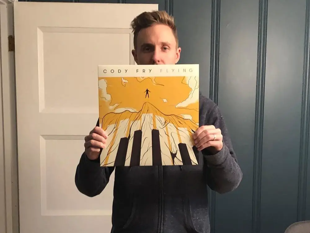 Photo of Cody Fry holding up one of his records