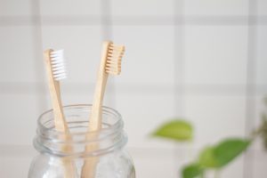 in an article about oral health, two toothbrushes in a jar