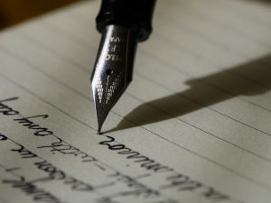 In an article about films about writers, a photo of a pen writing on some paper